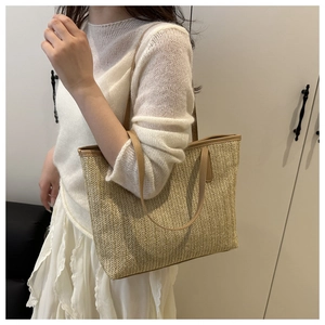 Détail de la texture tissée en chevrons et de la bandoulière en cuir marron du sac cabas