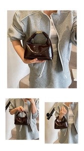 Gros plan sur la texture en cuir verni marron brillant et l'attache dorée chic