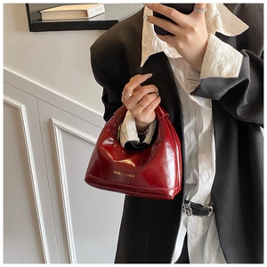 Détail macro du sac hobo en cuir verni bordeaux avec lettrage doré Fashion & Bags