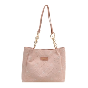 Pink quilted shoulder bag with white floral patterns and gold chain strap on white background