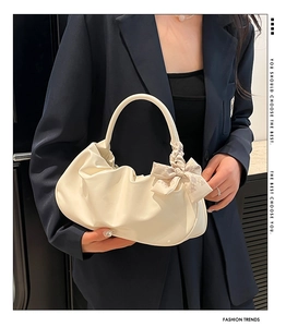 Dettaglio borsa a nuvola beige con morbida pelle plissettata e fiocco decorativo elegante