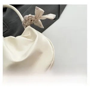 Dettaglio della borsa a nuvola increspata con manico avvolto in seta bianco crema