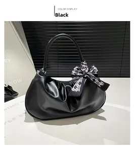 Dettaglio borsa a nuvola plissettata nera con fiocco a scacchi decorativo sul manico