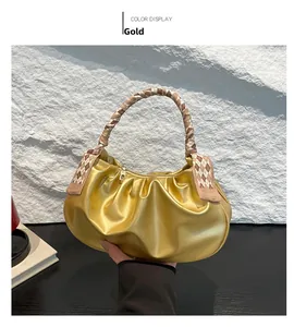 Dettaglio della borsa a nuvola dorata a pieghe con foulard di seta marrone sul manico