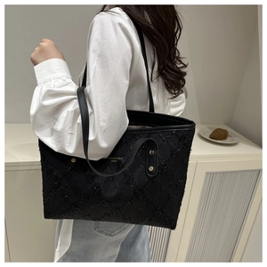 Detail of black sequined tote bag with diamond stitching and metallic brand logo