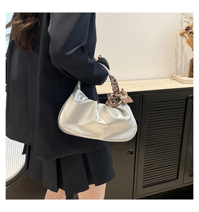 Silver pleated cloud bag with checkered silk scarf detail on handle shown on a model
