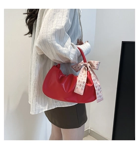 Vista laterale di una borsa cloud increspata rossa con foulard a scacchi sul manico