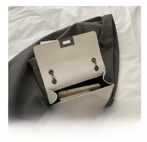Internal capacity of creamy square chain bag showing smartphone storage space