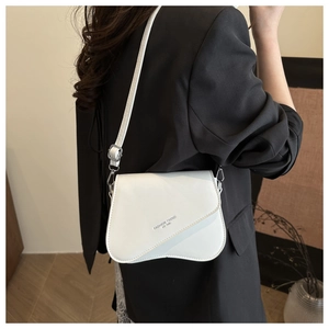 Detail of white leather crossbody bag with wave edge flap and fashion lettering