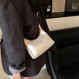 Borsa hobo bianco perla con scritta dorata abbinata a un blazer nero chic
