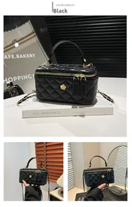 Macro shot of black quilted faux leather crossbody bag with gold camellia logo detail