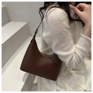 Detailed view of coffee brown crescent underarm bag with matte smooth faux leather texture