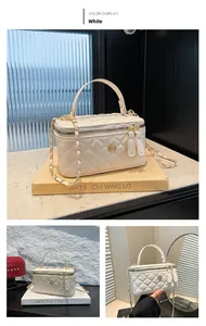 Close-up of white quilted leather bucket bag with gold chain strap and floral metal hardware