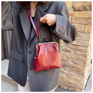 Detail of vintage red leather doctor bag with gold metal frame and ball clasp closure