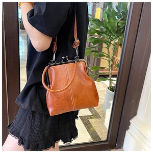 Detail view of brown vintage soft leather crossbody bag with white vertical stitching