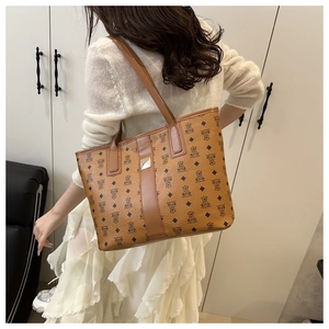 Gros plan du grand sac cabas marron à motif ours porté par un mannequin en robe