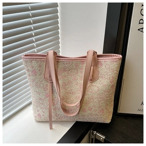 Detail of pink and beige woven tote bag with premium leather handles for summer