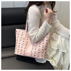 Detail of pink tote bag with bear monogram pattern on model in lifestyle setting