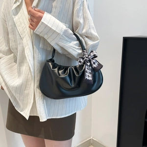 Black ruched cloud underarm bag with checkered scarf handle on a model