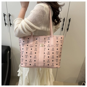 Sac cabas rose avec motifs d'ours et cuir grainé porté à l'épaule par un mannequin