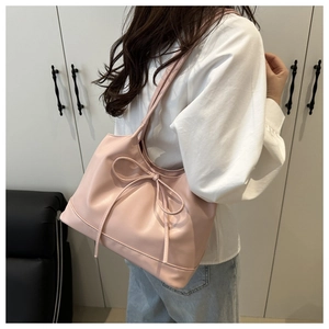Detail shot of pale pink tote bag with stylish bow accent and dual shoulder straps