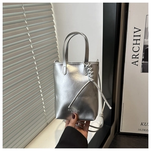 Détail d'un mini sac à main argenté métallisé avec inscription et bandoulière fine