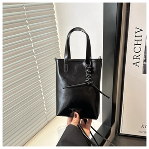 Détail du mini sac carré noir verni avec logo FASHION et décoration de nœud en corde