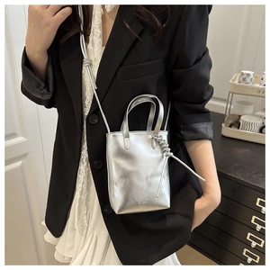 Mini sac à téléphone argenté avec inscription fashion sur une surface en cuir moderne