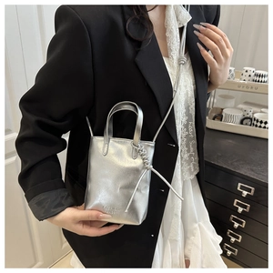 Détail d'un mini sac cabas argenté métallisé avec inscription et fine bandoulière