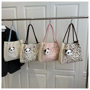Close-up of four woven tote bags featuring colorful patterns and cute panda charms