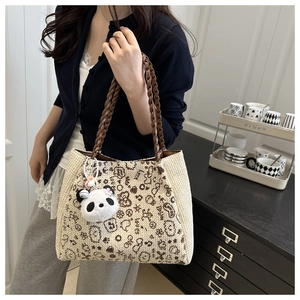 Détail du sac cabas tissé avec motifs graffiti d'ours et charmant pendentif panda