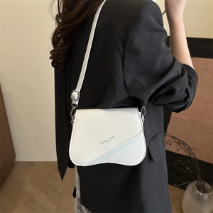 White leather minimalist saddle bag with unique asymmetrical flap and fashion trend logo