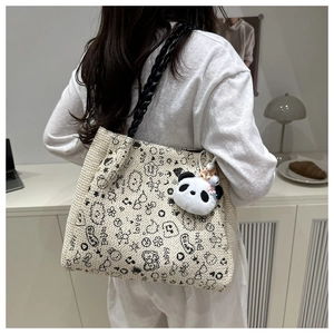 Détail du grand sac cabas en paille crème avec graffitis noirs et charme panda