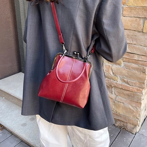 Retro red faux leather frame handbag with white stitching and detachable shoulder strap