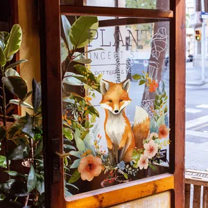 Detail of cute orange fox window decal with flowers on a glass door in a shop setting