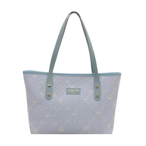Fashionable light blue quilted tote bag with floral embroidery and gold metal rivets