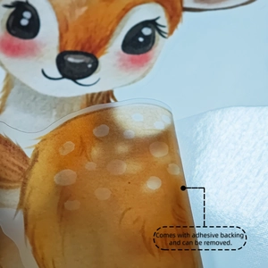 Detail showing cartoon deer wall sticker being peeled from backing to show adhesive