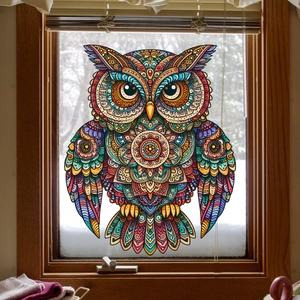 Colorful owl window sticker with mandala art patterns against a snowy outdoor background