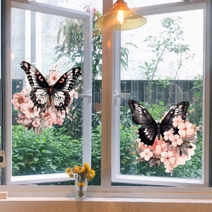 Close-up of butterfly and pink flower window stickers applied to clear glass surface