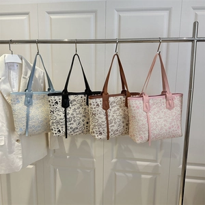 Four colorful woven tote bags with diverse patterns displayed on a minimalist metal rack