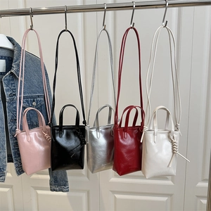 Mini sacs à main carrés en cuir brillant pour femmes en cinq couleurs présentés sur support