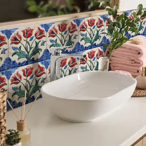 Detailed view of vintage floral tile backsplash behind a white ceramic oval basin