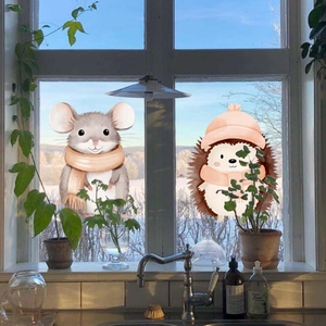 Detail van raamstickers met egel en muis in een gezellige winterse sfeer