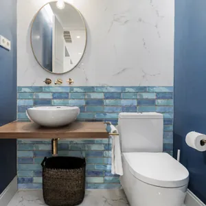 Detailed view of blue gradient subway tiles as a backsplash in a modern bathroom setup