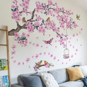 Detail of pink cherry blossom wall decals with birds and vintage cage in living room