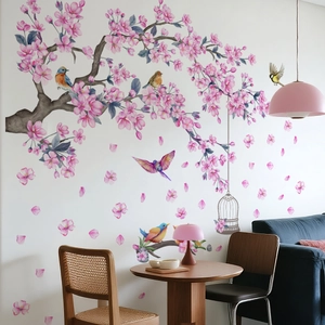 Detail of cherry blossom wall sticker with birds and birdcage on a white living room wall