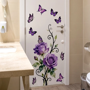 Détail de stickers muraux roses violettes et papillons sur une porte de salle de bain