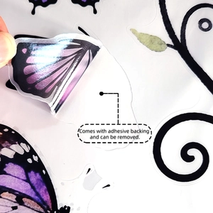 Détail d'un sticker papillon violet avec support adhésif décollé de son support papier