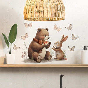 Detail of warm cartoon bear and rabbit wall stickers with butterflies on a white wall