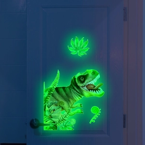Glow-in-the-dark T-Rex and fern plant wall stickers on a door in a dark room